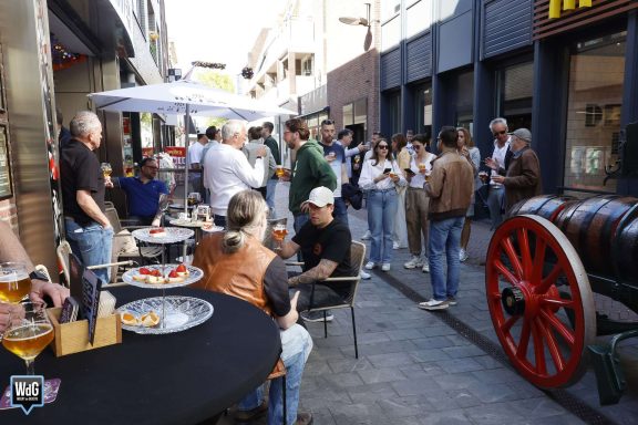 Een drukke straat met mensen die gezellig samenzijn en eten en drinken delen.