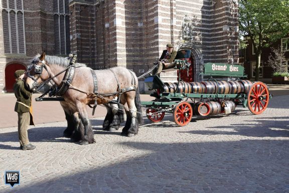 Paard met wagens, een traditionele brandweerwagen in een historisch stadsbeeld.